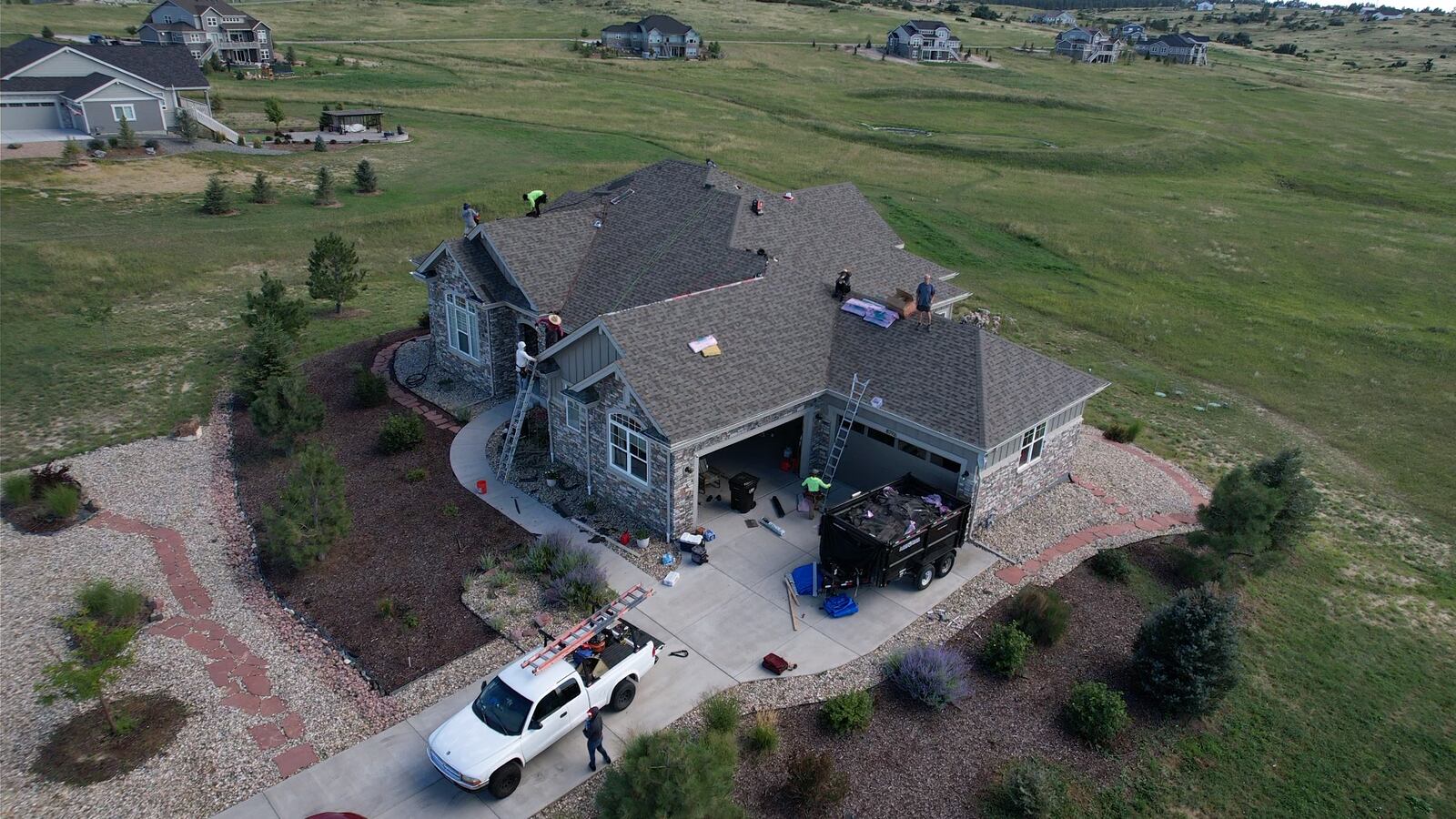 Two-story home in Parker, Colorado with a new dark asphalt shingle roof installed by ARCM Roofing